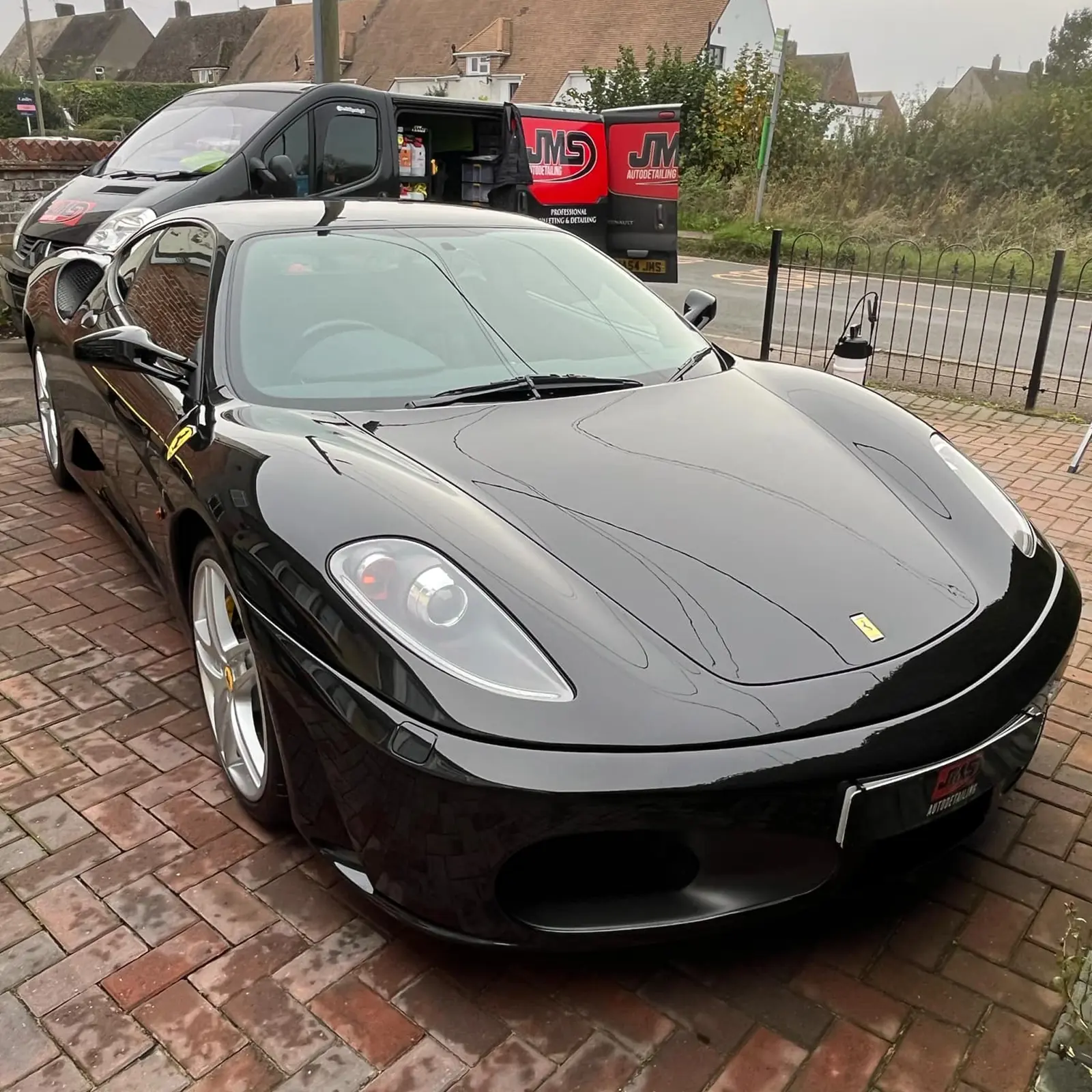Black Ferrari F430 gleaming on a driveway after a JMS detail